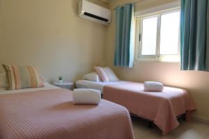 奥拉涅斯塔德Montana Eco Resort Aruba的客房设有两张床和窗户。
