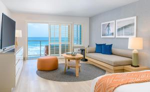 卡尔斯巴德Beach Terrace的一间卧室配有一张床、一张沙发和一台电视