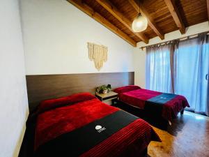 巴耶德布拉沃Casa Lunah Avandaro的配有红色和黑色床单的客房内的两张床