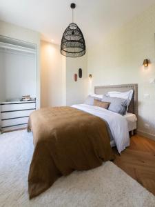 布雷斯特Le Siam的一间卧室配有一张带棕色毯子的大床