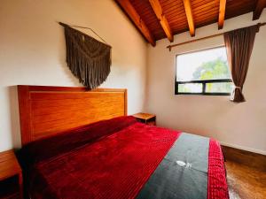 巴耶德布拉沃Casa Lunah Avandaro的一间卧室配有一张床铺,床上铺有红色毯子