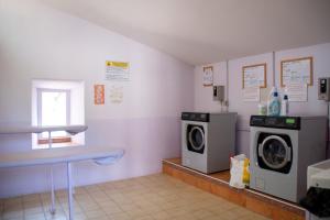 穆斯捷-圣玛丽Camping Le Saint Clair的洗衣房设有两台洗衣机和一扇窗户
