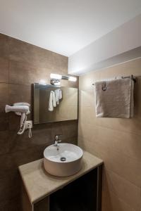 锡蒂亚Enastron Apartments的浴室设有白色水槽和镜子
