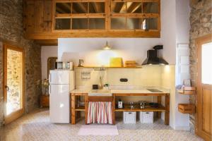 ArsèguelEl Mas de Sant Vicenç - apartamentos rurales的厨房配有白色冰箱和台面