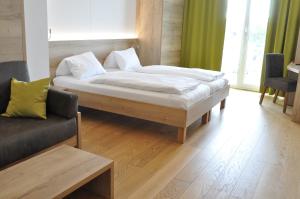 滨湖波德斯多夫赫林德湖滨酒店的一间卧室配有一张大床和一张沙发