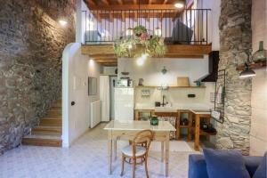ArsèguelEl Mas de Sant Vicenç - apartamentos rurales的厨房以及带桌椅的起居室。