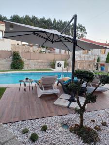 孔迪镇Luxury Vila with Spa and Pool的一个带遮阳伞和椅子的庭院和一个游泳池