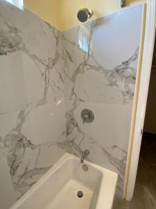 阿罗约格兰德海滩路酒店的浴室配有白色浴缸和大理石墙。