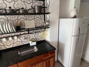 伊利亚贝拉Residencial Solariun Ilhabela的厨房配有白色冰箱和黑色台面