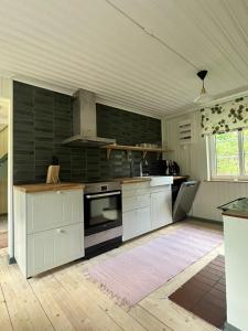 南雪平Charlottenborg的厨房配有白色橱柜和炉灶。