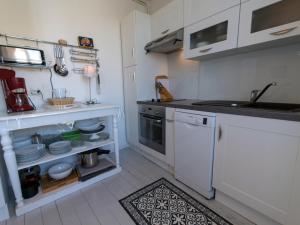 勒帕莱Appartement Le Palais, 3 pièces, 4 personnes - FR-1-418-80的小厨房配有白色橱柜和水槽