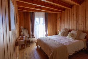 朗戈涅La Cabane du Petit Tour的卧室配有床、椅子和窗户。