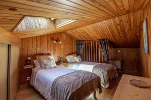 朗戈涅La Cabane du Petit Tour的小木屋内一间卧室,配有两张床