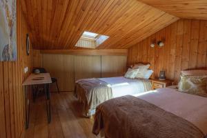 朗戈涅La Cabane du Petit Tour的小木屋内一间卧室,配有两张床