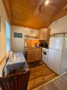 林肯维尔Pine Grove Cottages的厨房配有桌子和白色冰箱。