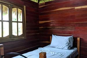 BalgueWood Cabin - Cabana Maderas的小木屋内的一张床位,设有窗户