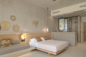 普拉基亚斯NERĒA Boutique Hotel的卧室配有白色的床和沙发