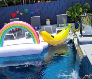 劳德代尔堡Casa806 Men Only Guest House的一个带滑梯和一束香蕉的游泳池