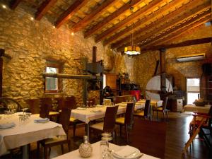L'Aldea马斯马斯多旅馆的石头建筑中带桌椅的餐厅