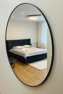 帕内韦日斯S&A apartamentai的卧室内的镜子反射着一张床