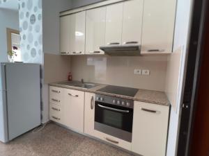 维利波吉Bella View Apartment的厨房配有白色橱柜、炉灶和冰箱。