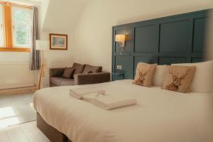皮特洛赫里Ballinluig Rooms & Suites的一间卧室配有一张白色大床和绿色床头板