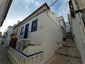 纳扎雷Casa Pisa Flores - Praia da Nazaré的白色的建筑,在街上有蓝色的窗户