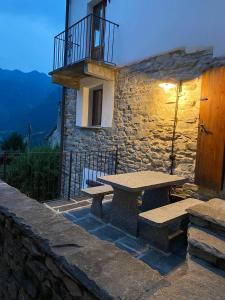 LionzaCasa Mille Sassi的石头建筑,设有野餐桌和阳台