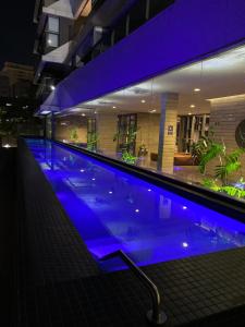 圣保罗VN Oscar Freire - O Melhor de Pinheiros的大楼内带蓝色灯光的大型游泳池