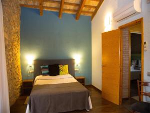 L'Aldea马斯马斯多旅馆的一间卧室设有一张床和蓝色的墙壁
