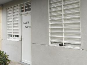 马德里Apartamento Madrid Norte的建筑物一侧有标志的窗户