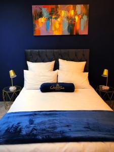 开普敦Queen Julie Lodge的卧室配有一张白色大床,墙上挂有绘画作品