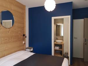 AvajanLe Relais d'Avajan的一间卧室设有蓝色的墙壁、一张床和一个水槽