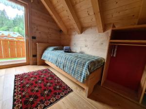 坎波罗索因瓦尔坎纳尔Chalet Camporosso的小木屋内的卧室,配有一张床和地毯