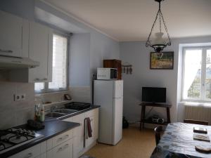 PolignacCHEZ GRAND MAMIE的厨房配有白色冰箱和桌子