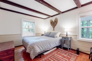 吉尔福特Gunstock Getaway的一间卧室设有一张床和两个窗户。