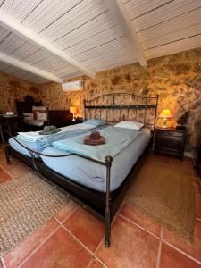 桑坦伊Finca Es Velar的一张大床,位于一个石墙房间内