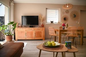Hindisheim214 A‘coeur的客厅配有电视和一张带一碗水果的桌子