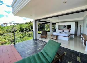 芭东海滩Andaman Hills - panoramic sea view house in Patong的别墅内一间卧室,配有一张床和一个阳台