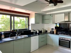 芭东海滩Andaman Hills - panoramic sea view house in Patong的厨房配有白色橱柜和吊扇