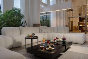 米兰NH Collection Milano CityLife的客厅配有白色大沙发和桌子