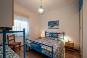 普罗斯西托角Villa Susy的一间卧室配有蓝色的床和椅子
