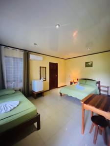 德雷克Cabinas Villa Drake的酒店客房设有两张床和一张桌子。