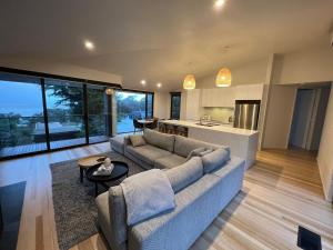 洛恩Architect designed 4 bedroom with ocean views from every room的带沙发的客厅和厨房