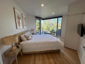 洛恩Architect designed 4 bedroom with ocean views from every room的一间卧室设有一张床和一个大窗户