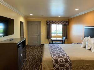 拉蓬特Industry Inn & Suites的配有一张床和一台平面电视的酒店客房
