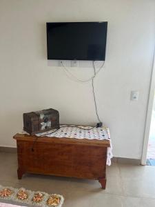 福米加Pousada Dona Terezinha的配有电视和比萨饼桌子的房间
