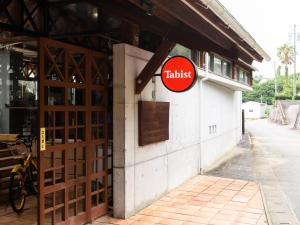 志摩市Tabist Villa Daio Resort Ise-Shima的大楼一侧有标志的餐厅