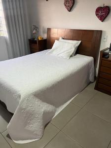 福米加Pousada Dona Terezinha的卧室配有白色的床和木制床头板