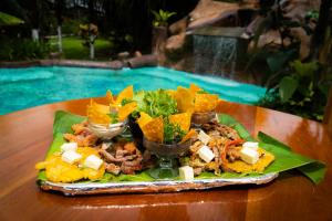 福尔图纳Hotel & Hot Springs Sueño Dorado的池边桌子上的一盘食物